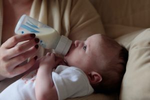 Mother bottle feeding a young baby
