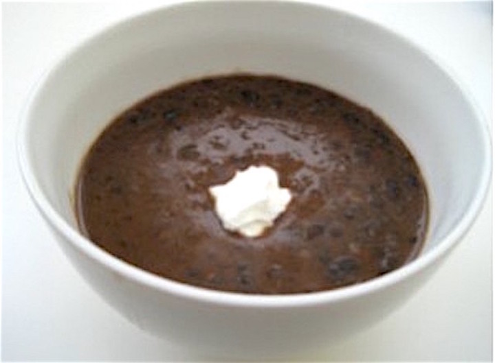 bowl of black bean soup with a garnish of sour cream.